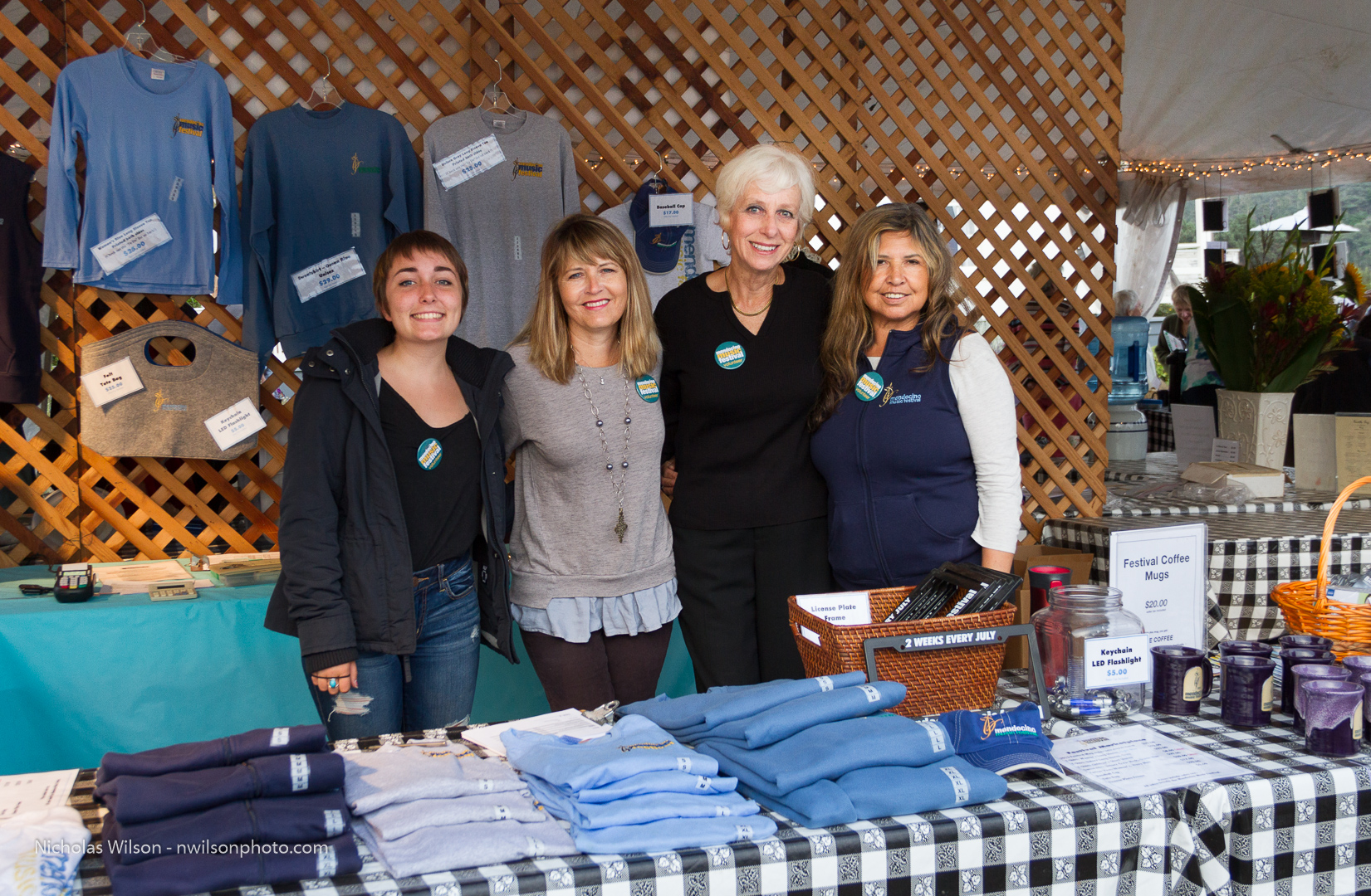 Leona Walden and Sally Stewart with two other volunteers in the festival merchandise booth.