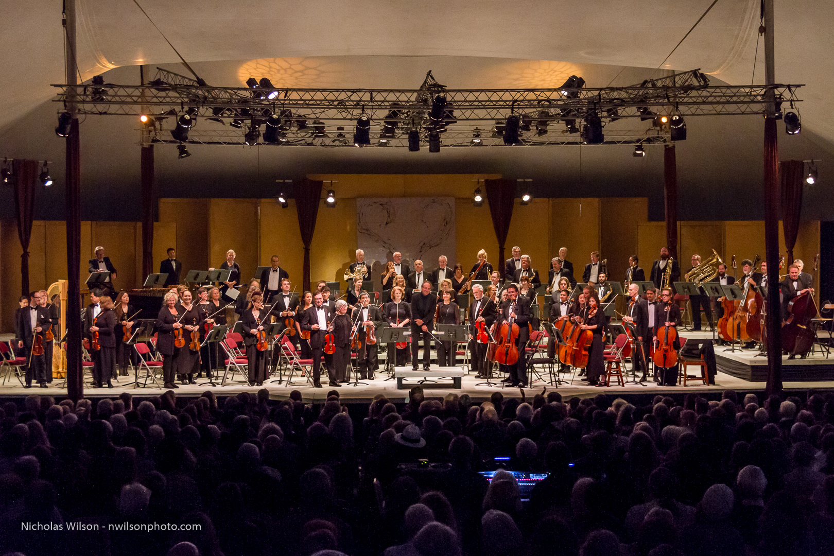 The festival orchestra stands to acknowledge applause at the start of the opening concert