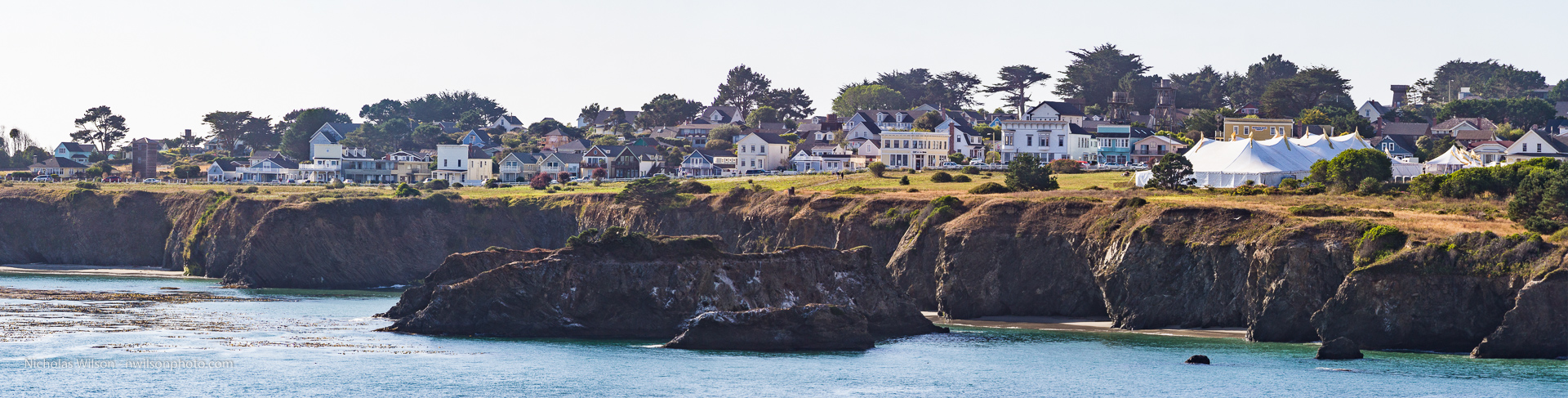 Panoramic view of Mendocino across Mendocino Bay. The music festival's big top tent has been a landmark every July since 1986.
