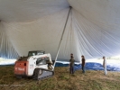 David Lindstrom's agile Bobcat dozer lifts a pole and hundreds of pounds of canvas into place.